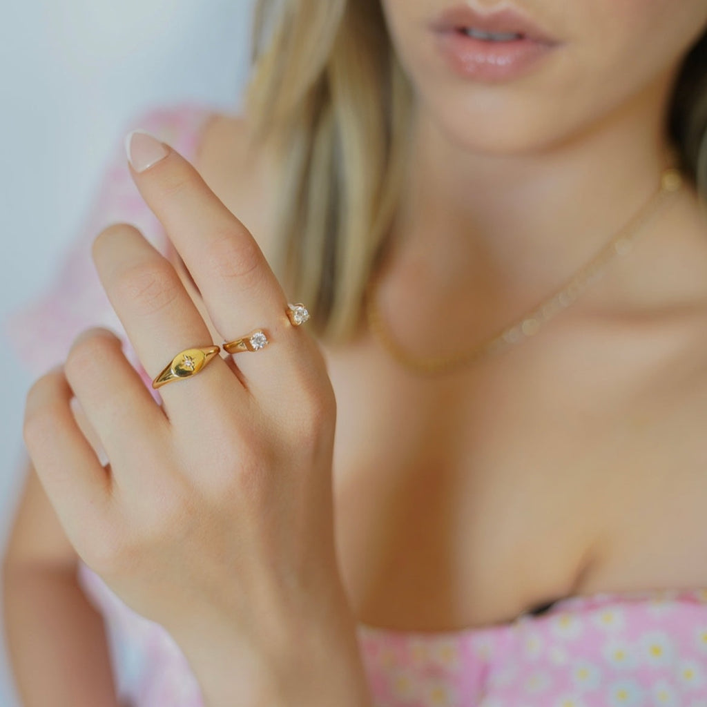 Feel like a shining star in our 18K Gold plated. The ring features a thick gold plated  band adorned with zirconia  set in a striking engraved starburst design. Full of glimmer, this star ring will light up your hand and make your casual wear sparkle.
